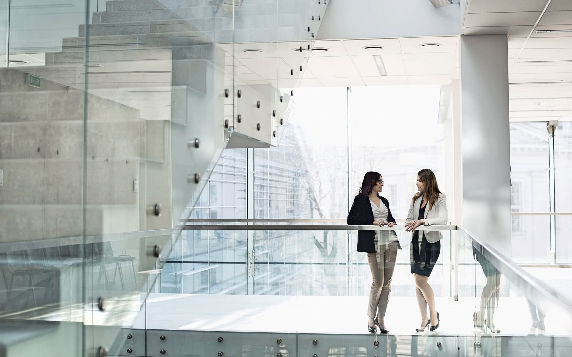 Front View Of Two Women Conversing In Office Building