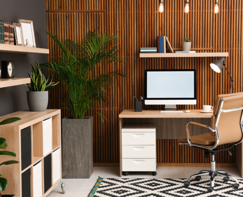 Comfortable Workplace With Computer Near Wooden Wall In Stylish Room Interior